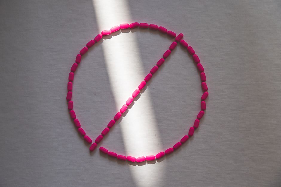 Pills arranged in a prohibition symbol illustrating the legal risk of darknet markets
