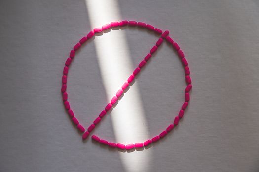 Pills arranged in a prohibition symbol illustrating the legal risk of darknet markets